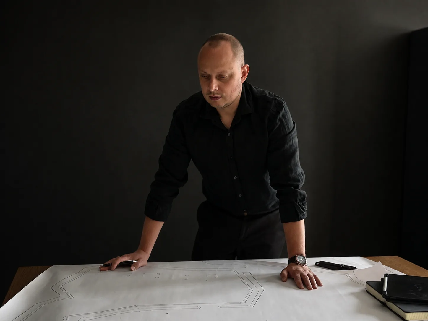 Radosław Nicgorski studying maps and drawings in the studio